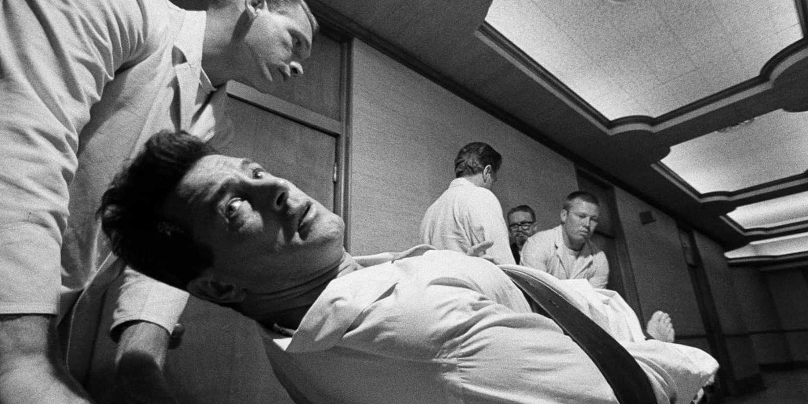 Rock Hudson being wheeled on a hospital stretcher by several men in Seconds (1966)