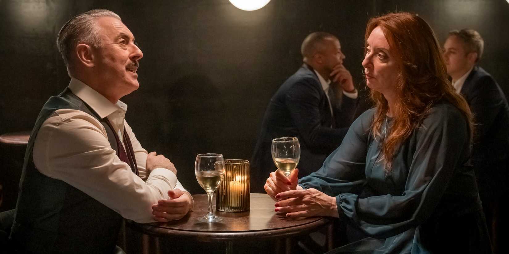 Alan Cumming as Leo Struthers sitting at a table across from Elizabeth Barrington as Stephanie in Tip Toe