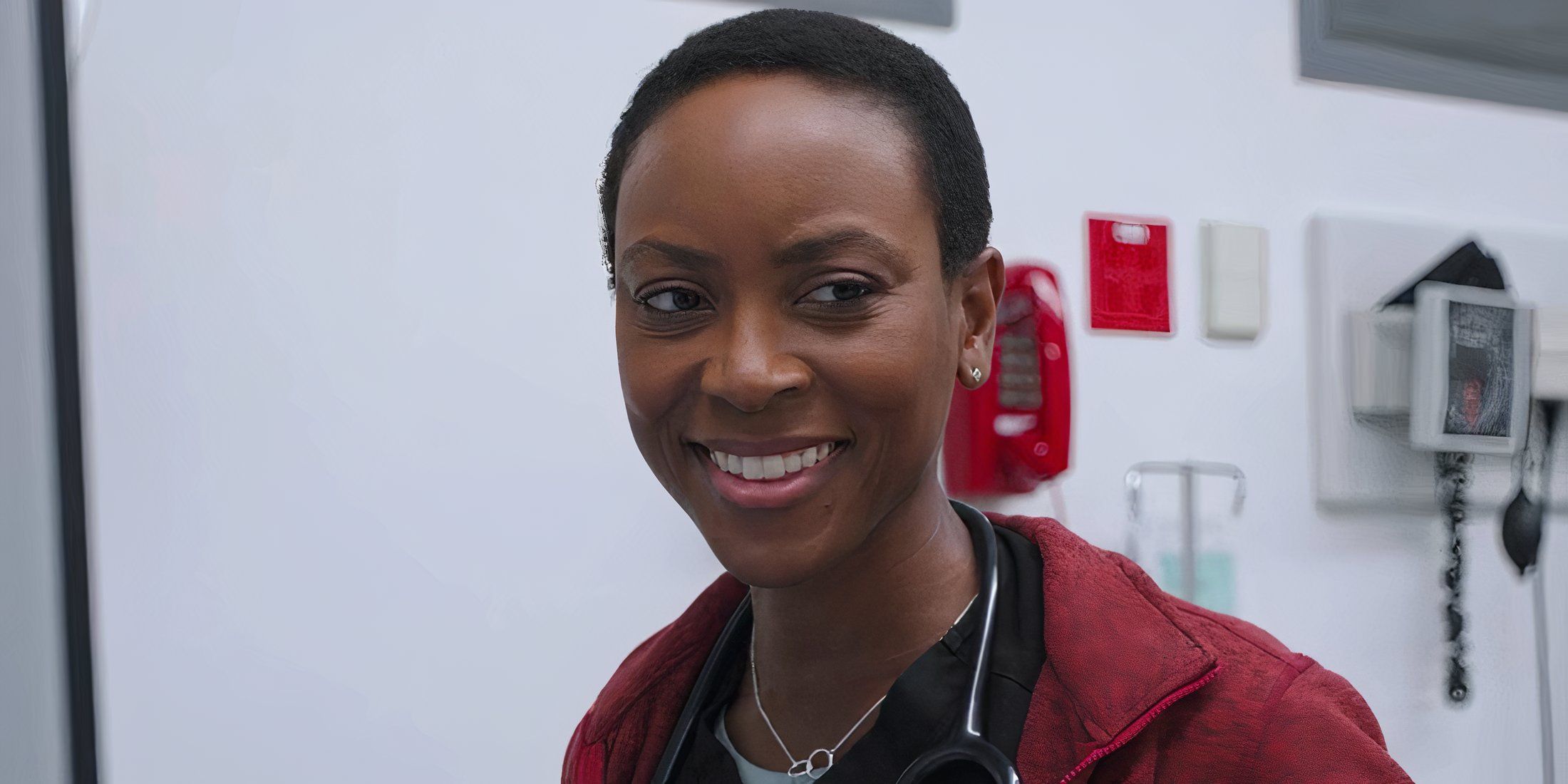 Dra. Heather Collins sorrindo em um episódio da 1ª temporada de The Pitt.