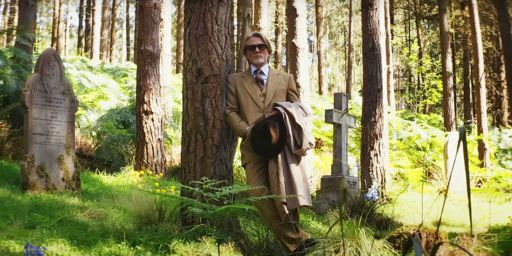 daniel-craig-leaning-up-against-a-tree-in-a-cemetery-in-knives-out-wake-up-dead-man.jpg