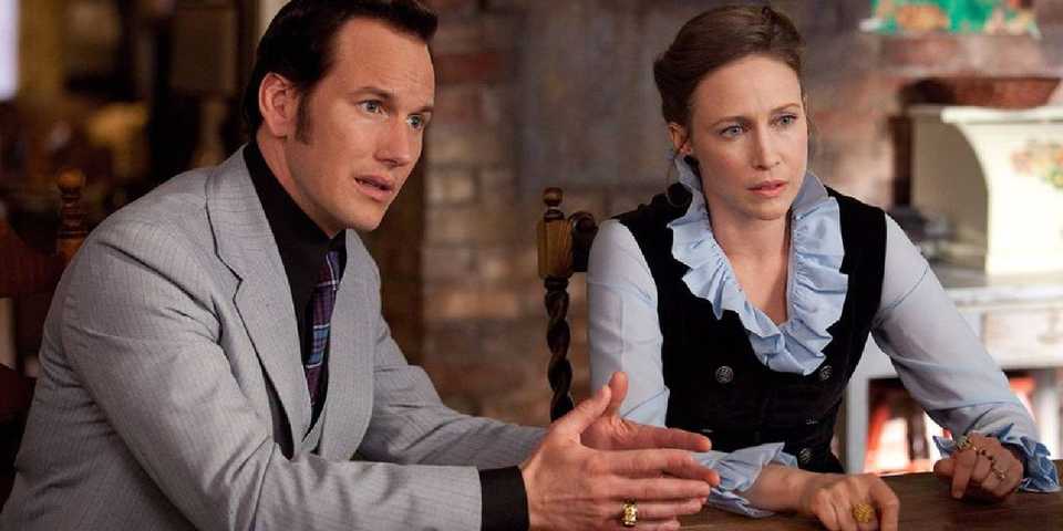 Patrick Wilson and Vera Farmiga as Ed and Lorraine Warren sitting in The Conjuring