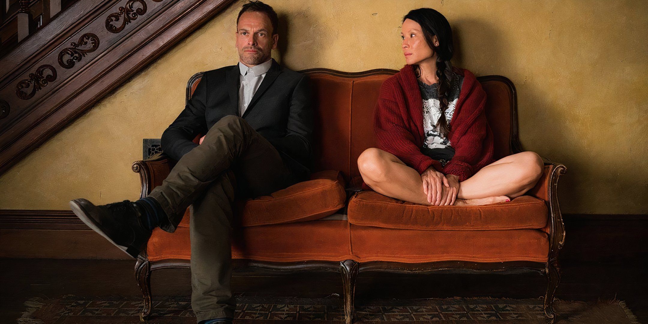 jonny-lee-miller-s-sherlock-and-lucy-liu-s-joan-sitting-on-a-couch-with-each-other-in-elementary.jpg