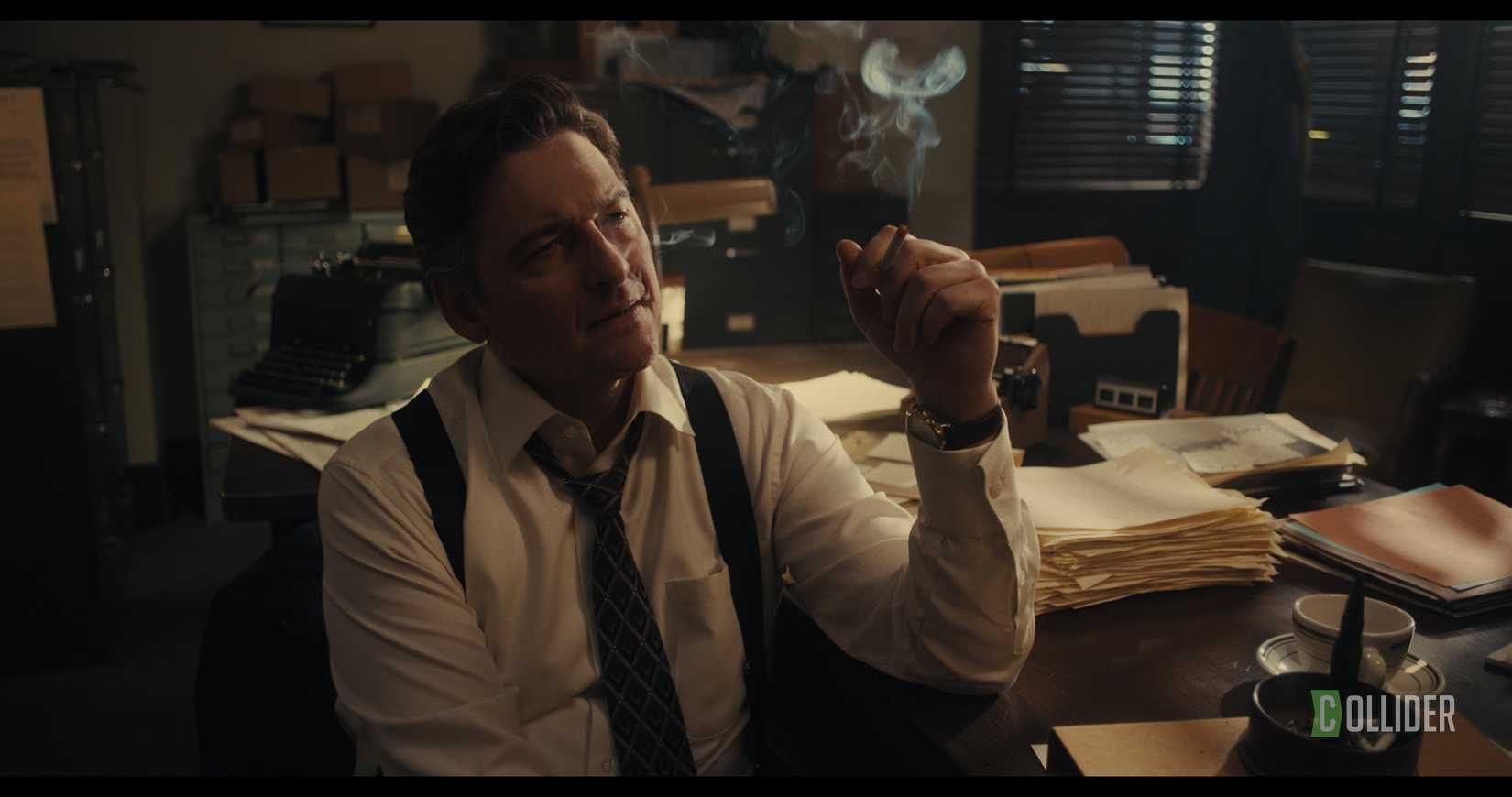 Toby Leonard Moore sitting at his desk with a cigarette in Red Ink